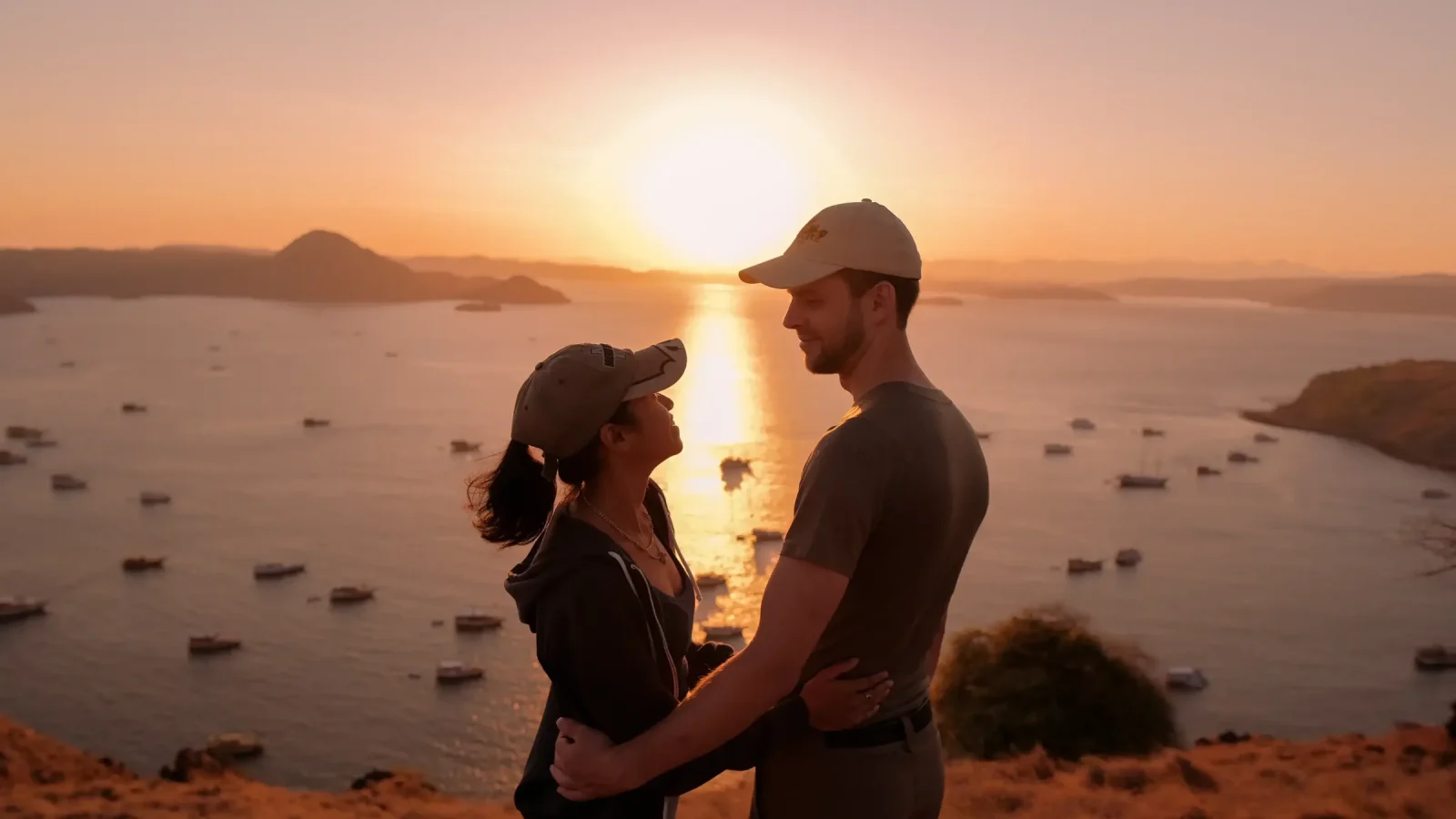 A couple watching sunset over the boats anchored off Labuan Bajo