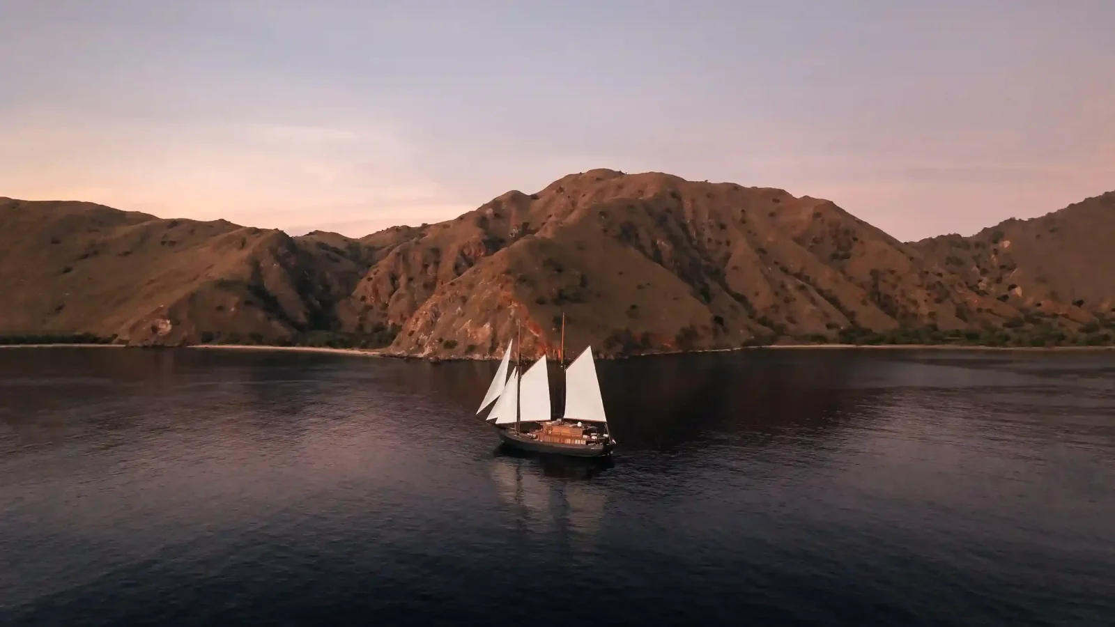 A phinisi at anchor in calm water off Labuan Bajo